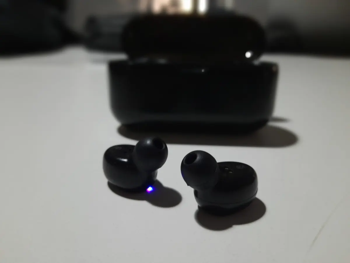 Tai nghe true wireless màu đen cạnh hộp sạc